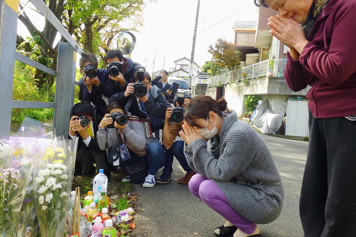 Местные жители молятся у мемориала рядом с домом Сираиси